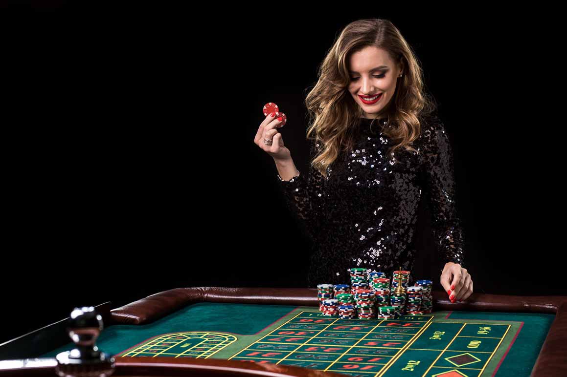Sexy woman in a black dress playing in casino. Woman stakes pile